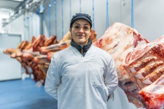 Frontal formal portrait of a happy caucasian adult woman butcher with laboratory coat and hygienic