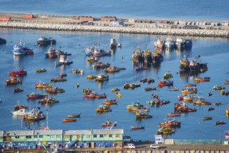 View from the Morro de Arica lookout mountain of the small colourful ships and boats in the fishing