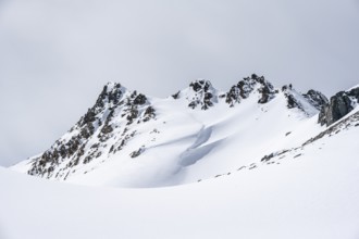Minimalist winter landscape, white snow and dark mountains on the Scalettahorn, Graubünden,
