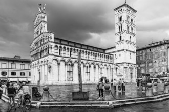 Dark rain clouds over the bell tower of the church of San Michele in Foro, and Piazza San Michele,
