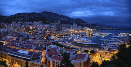 Aerial panorama of Monaco Monte Carlo harbour and illuminated city skyline in the evening blue hour