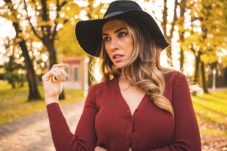 Lifestyle, portrait of a caucasian girl with a hat in a forest walking in autumn