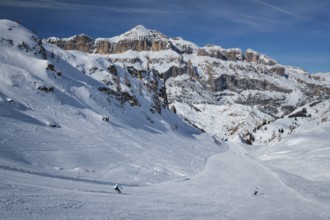 View of a ski resort piste with people skiing in Dolomites in Italy. Ski area Arabba. Arabba,