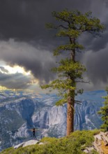 A young woman in Sentinel Dome looking at Upper Yosemite Fall, Yosemite National Park. United