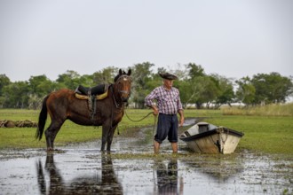 Gaucho with horse and boat at Puesto Mingo, Esteros del Iberá, near Concepción del Yaguareté Corá,