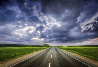 Travel concept background, road and stormy dramatic sky