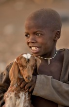 Himba boy with a goat, Ombombo, Kaokoland, Kunene, Namibia, Africa