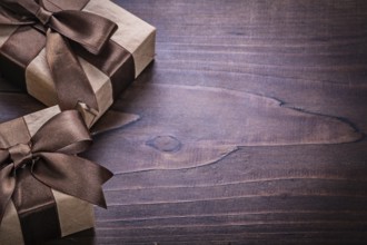 Two vintage gift boxes covered crumpled paper with copyspace on old wooden board holiday concept