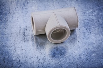 Plastic T-tube on metallic background construction concept