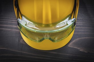 Safety glasses and building helmet on vintage wooden board