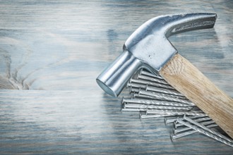 Claw hammer nails on wooden board construction concept