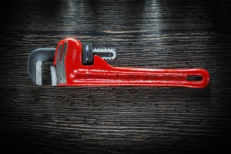 Pipe wrench on vintage wooden board