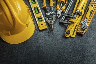 Set of yellow construction tools on black background