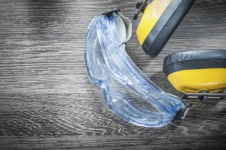 Safety spectacles earmuffs on wooden board