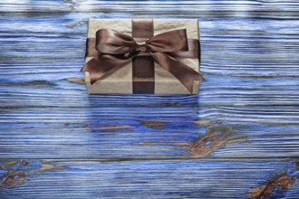 Wrapped brown present box on vintage wooden board