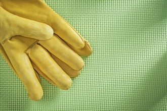 Leather safety gloves on green background construction concept