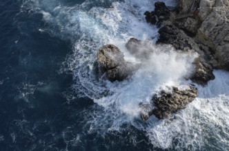 Drone aerial of rocky coast and stormy waves. Seascape windy waves. Stormy sea. Nature background.