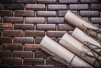Rolled vintage documents on wicker wooden matting