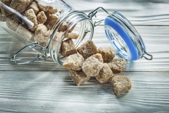 Brown sugar cubes jar on wooden board