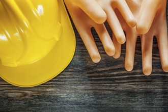 Hard hat insulating gloves on wooden board