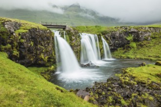 Iceland - country of mountains, rivers and waterfalls. Threaded full-flowing waterfall on the