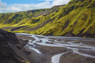 Canyon Pakgil in Iceland. Picturesque basalt hills covered with green grass and moss-polar. Streams