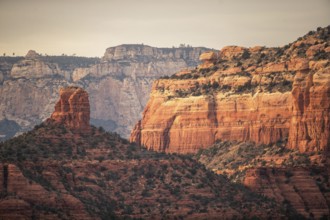 Majestic red rock formations and cliffs in a desert landscape under a clear sky in Sedona, Arizona,