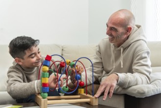 Grandfather and grandson enjoying quality time together, playing with a colorful wooden bead maze