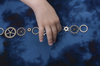 Wooden cogwheels on a fabric industry concept information