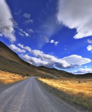 The dirt road in the Chile National Park Torres del Paine. Magic clouds incredible shapes formed by