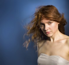 Beauty fashion portrait. Beautiful young woman on blue wall background