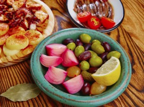 Olives and onion pickles tapas with anchovies and octopus gallega