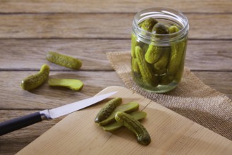 Bottled pickles cucumbers in vintage wooden table