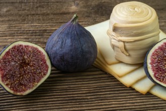 Figs, various cheese on a rustic table.Traditional hand made slovak smoked cheese parenica. Healthy