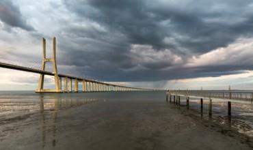 Vasco da Gama Bridge at sunset with dramatic cloudy blue sky in Lisbon, Portugal, Europe