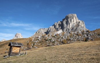 Beautiful mountain landscape with Dolomite rocky peak and a wooden lodge at picturesque Passo Di