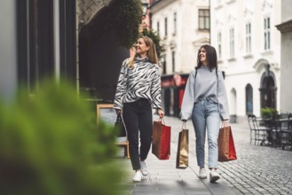 Two young caucasian women having fun on city street outdoors, Best friends enjoying a holiday day