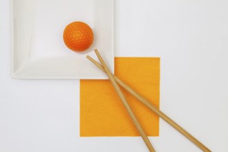 Top View Of White Empty Sushi Plates With Bamboo Chopsticks and Golf Ball. Golf Design