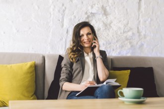 Businesswoman Using Phone Working On Laptop In Coffee Shop. woman calling with cell telephone,