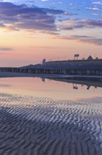 Beautiful Sunset at the seaside in the Netherlands with pastel colours in the clouds and the water
