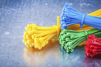 Multicolored plastic zip cable ties on metallic background construction concept