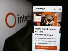 Stuttgart, Germany, 07-21-2024: Person holding cellphone with webpage of German mortgage brokerage
