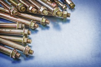 Variation of metal anchor bolts with construction nuts on metallic background repairing concept