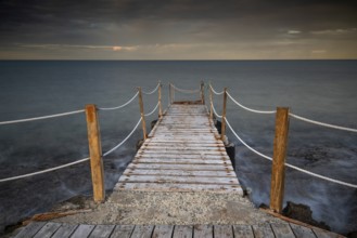 Long wooden pier in the sea at sunset. Protaras Cyprus
