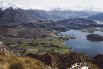 View of a wide valley with a lake, surrounded by fields and mountains, Roys Peak, Wanaka, New