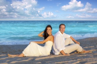 Couple in love sitting in blue beach on vacation travel