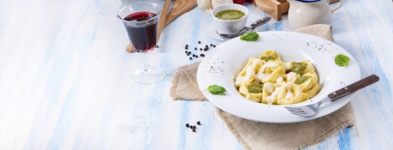 Tortellini di formaggio with basil pesto and cheese sauce