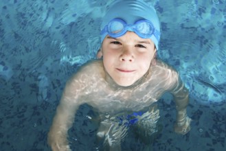 Little boy in swimming pool. Blue swimming pool