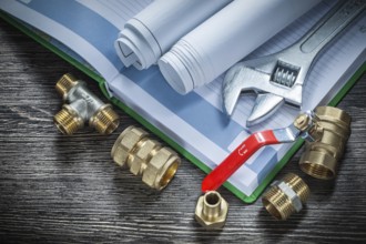 Adjustable spanner plumbing pipe connectors rolled blueprints water valve notebook pen