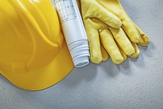 Building helmet protective gloves engineering drawings on concrete surface construction concept
